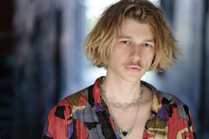 Max Hofmann posing for a photoshoot by wearing blue shirt.
